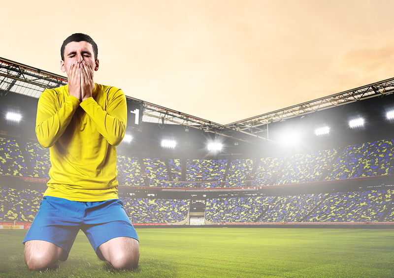 player kneeling hands on phase in football stadium